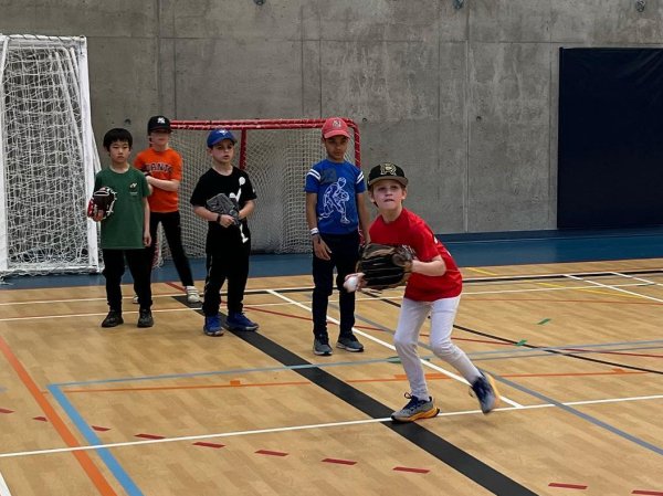 Baseball player doing throwing drills indoors