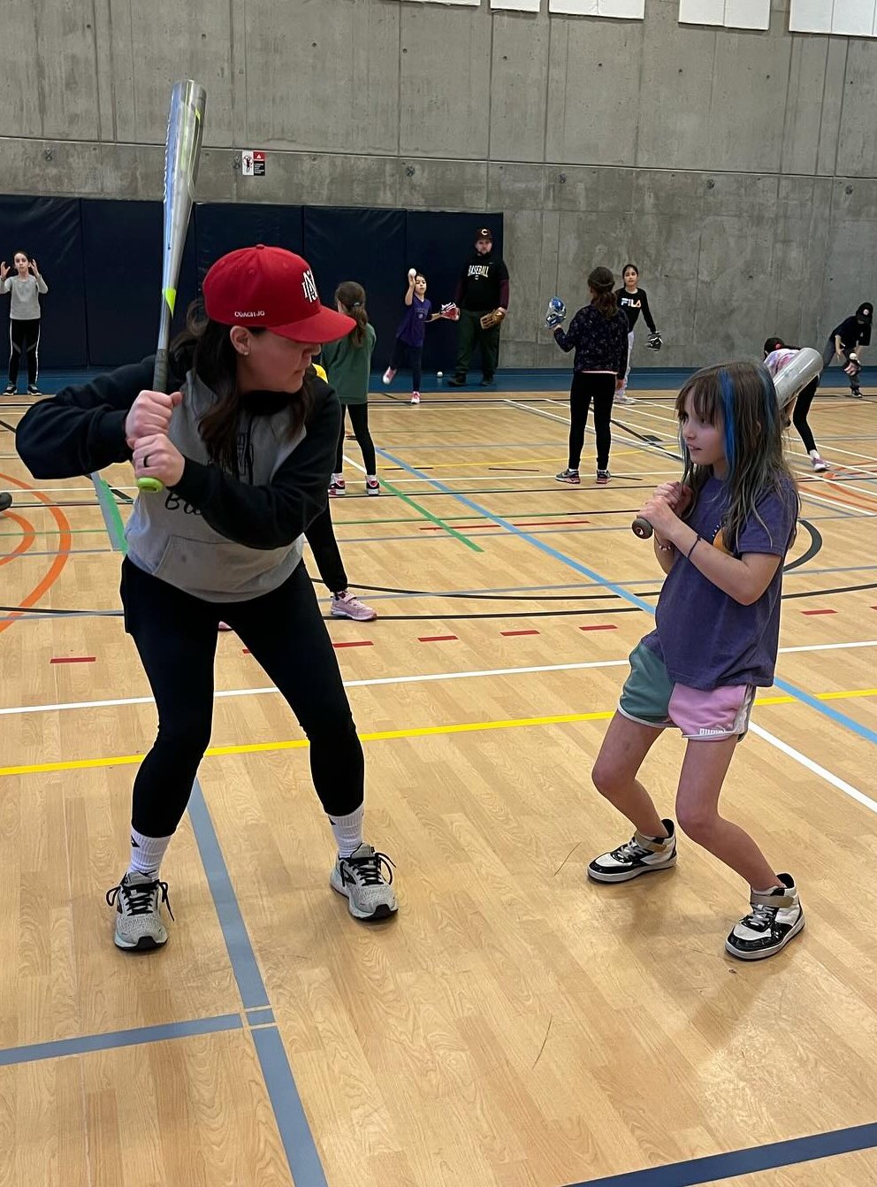 Baseball coach demonstrating correct batting technique